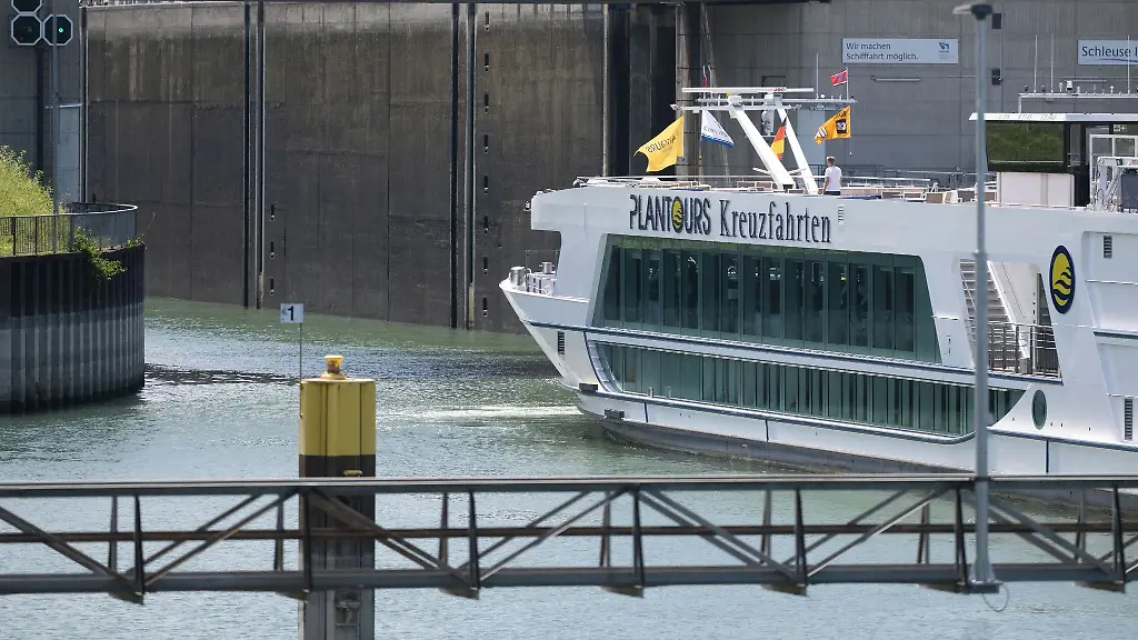 Ein-kleines-Flusskreuzfahrtschiff-wird-im-Schleppverband-in-die-Schleuse-Iffezheim-gebracht