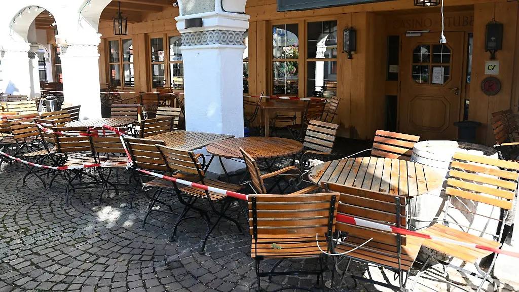 Die-Tische-und-Stuehle-eines-Restaurants-sind-mit-einem-Flatterband-abgesperrt