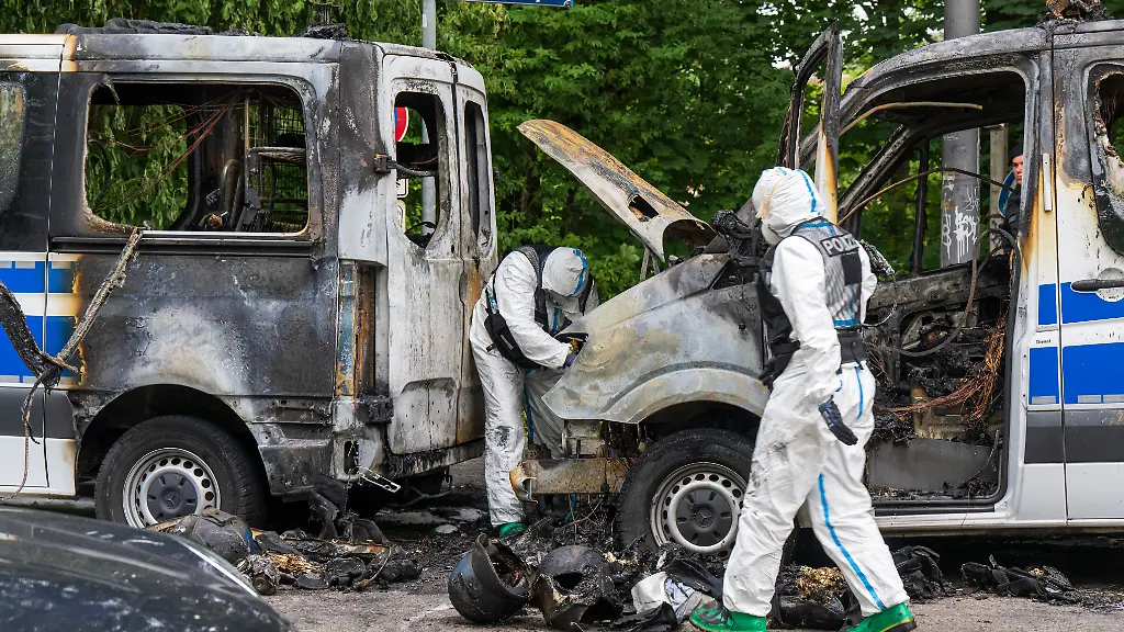 Ermittler-der-Spurensicherung-arbeiten-an-einem-Polizeiauto-das-in-der-Nacht-ausgebrannt-ist