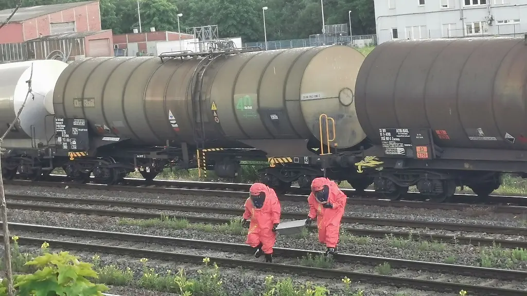 Einsatzkraefte-in-Chemikalien-Schutzanzuegen-fangen-Saeure-in-Edelstahlwannen-auf