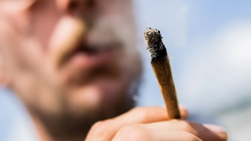 Ein-Mann-raucht-bei-der-Auftaktkundgebung-einer-Demonstrationen-fuer-eine-zuegige-Legalisierung-von-Cannabis-dem-Global-Marijuana-March-2022-am-Brandenburger-Tor-einen-Joint