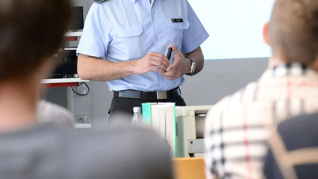 Ein-Oberleutnant-spricht-in-einem-Gymnasium-vor-einer-Klasse-und-stellt-die-Arbeit-der-Bundeswehr-vor