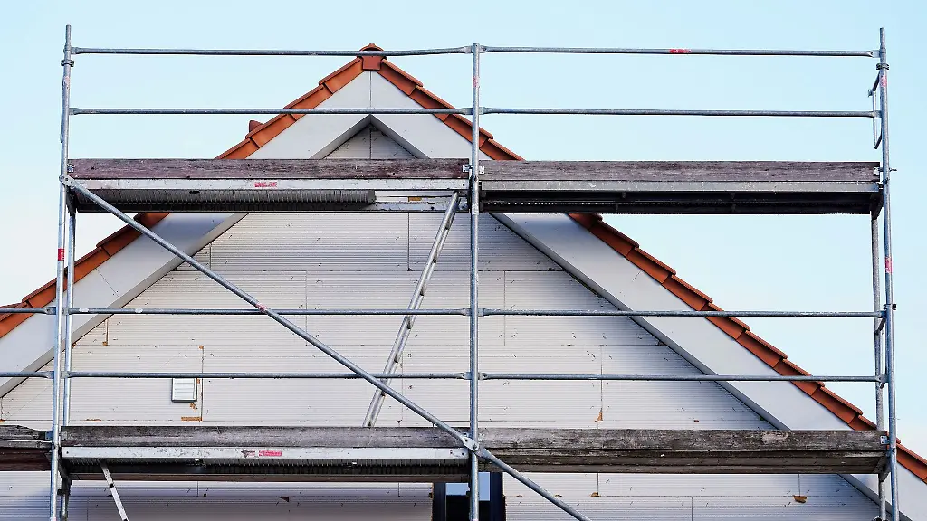 Ein-Baugeruest-steht-in-einem-Neubaugebiet-an-einem-Rohbau