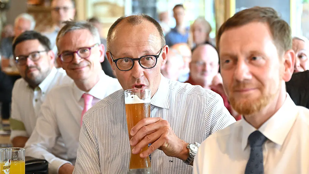 Friedrich-Merz-2-v-r-trinkt-bei-der-Wahlveranstaltung-der-CDU-Sachsen-und-der-CDU-Dresden-zur-OB-Wahl-neben-Michael-Kretschmer-ein-Bier