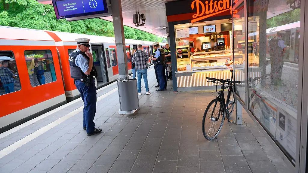 Ein-Bundespolizist-schaut-auf-ein-Fahrrad-das-an-Informationstafeln-auf-einem-Bahnsteig-lehnt