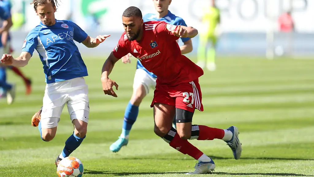 Josha-Vagnoman-vom-Hamburger-SV-r-im-Kampf-um-den-Ball-mit-Bentley-Baxter-Bahn-l-von-Hansa-Rostock