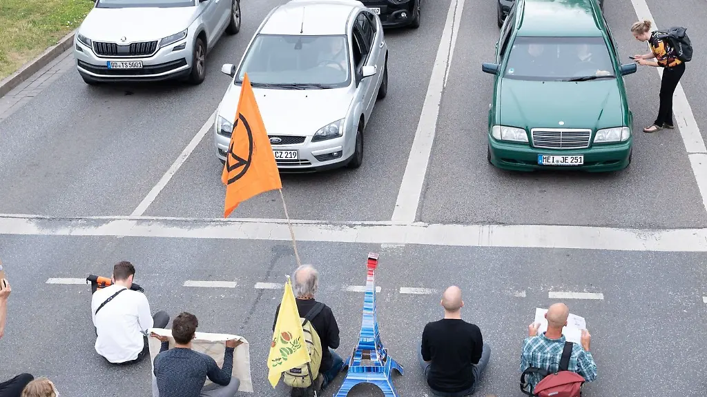 Umweltaktivisten-der-Gruppe-Letzte-Generation-sitzen-waehrend-einer-Demonstration-auf-der-Fahrbahn