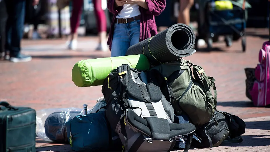 Rucksaecke-liegen-vor-dem-Bahnhof-auf-der-Strasse