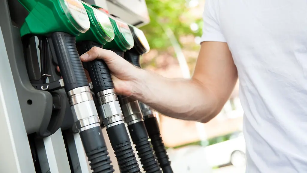 Ein-Mann-greift-an-einer-Tankstelle-nach-einem-Zapfventil