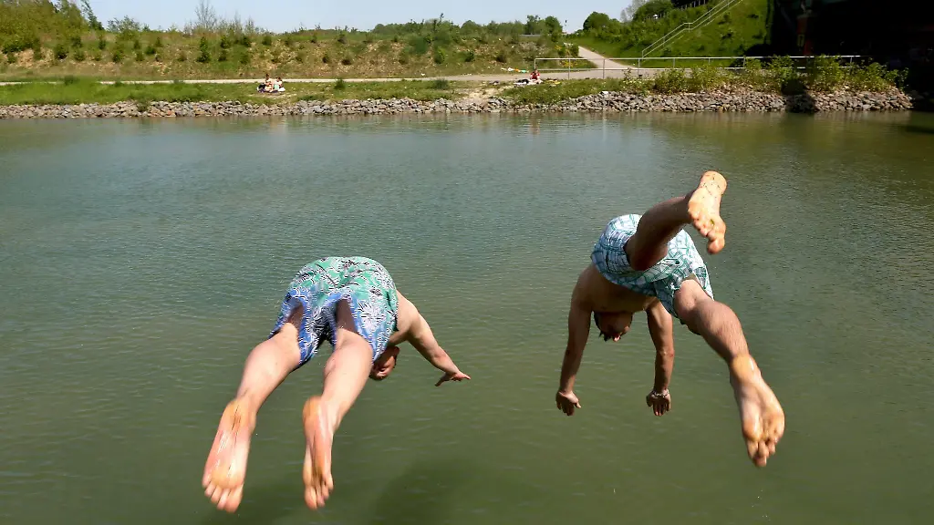 Zwei-junge-Maenner-springen-ins-Wasser