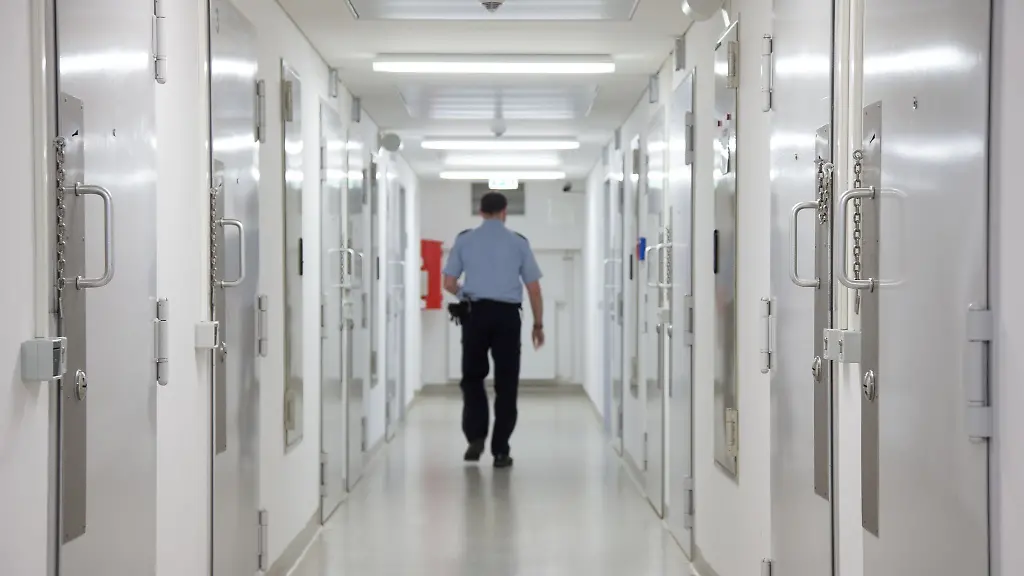 Ein-Justizbeamter-geht-durch-einen-Flur-der-Justizvollzugsanstalt-Bielefeld-Senne