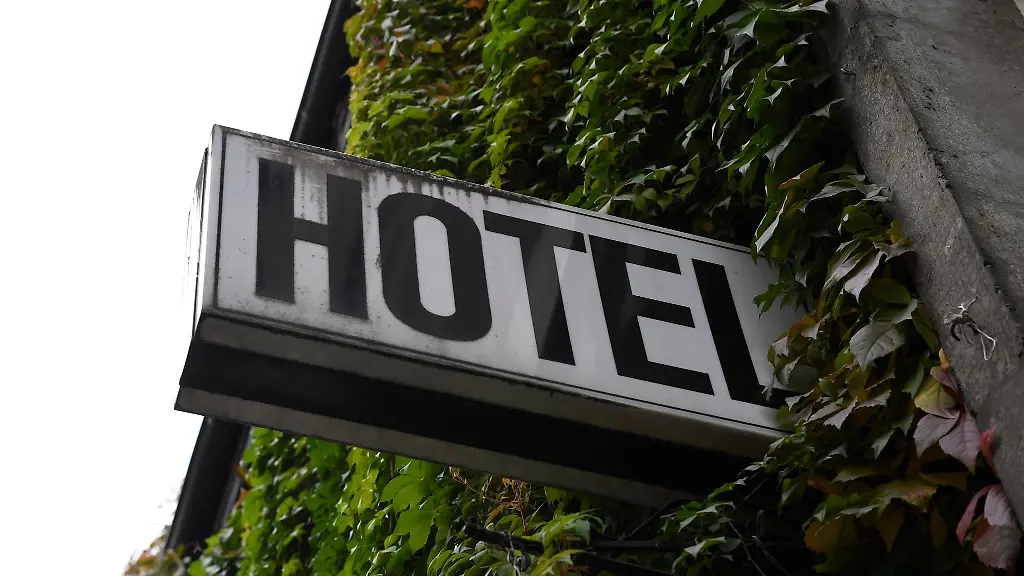 Ein-Leuchtschild-haengt-an-der-Fassade-eines-Hotels