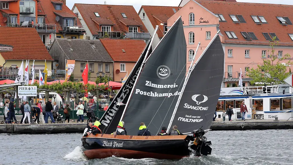 Waehrend-der-Mueritz-Sail-ist-ein-Segelkutter-bei-stuermischen-Boeen-im-Stadthafen-unterwegs