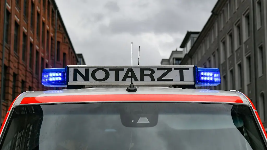 Ein-Notarztwagen-steht-mit-eingeschaltetem-Blaulicht-auf-der-Strasse