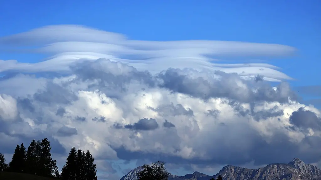 Unterschiedliche-Wolkenformationen-tuermen-sich-ueber-dem-Panorama-der-Alpen-bei-Unterthingau
