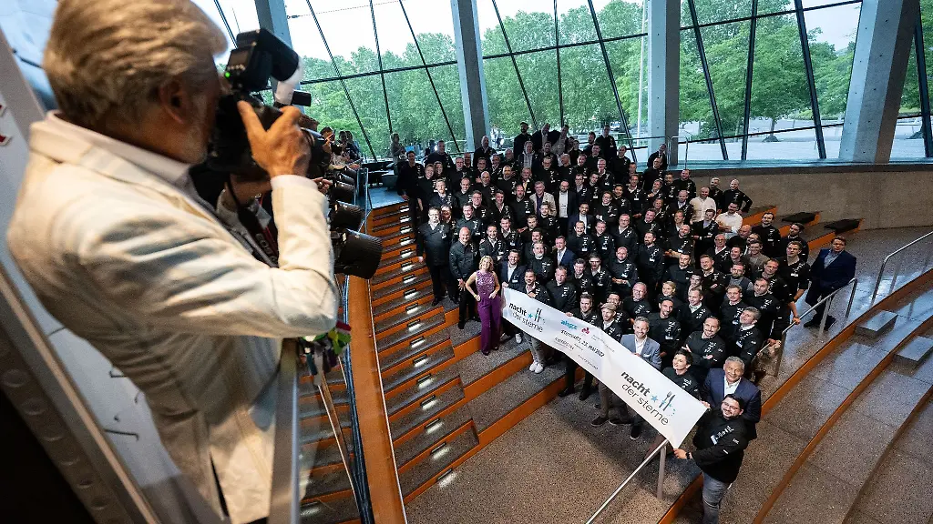 Sternekoeche-stehen-mit-Veranstaltern-der-Nacht-der-Sterne-2022-und-Fernsehkoechin-Felicitas-Then-lila-Kleid-zu-einem-Gruppenfoto-zusammen