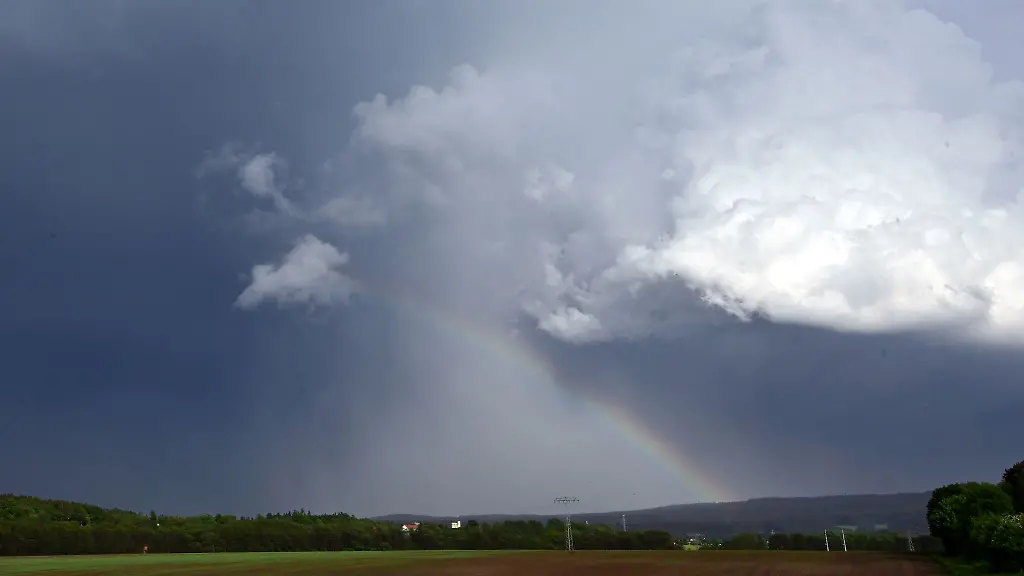 Ein-Regenbogen-bildet-sich-vor-dunklen-Wolken