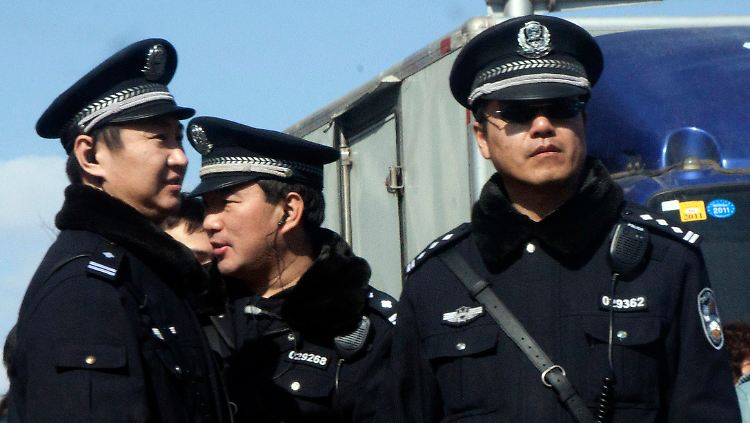 Chinesische Polizisten überwachen das Xidan Einkaufszentrum in Peking, wo Proteste angekündigt sind.