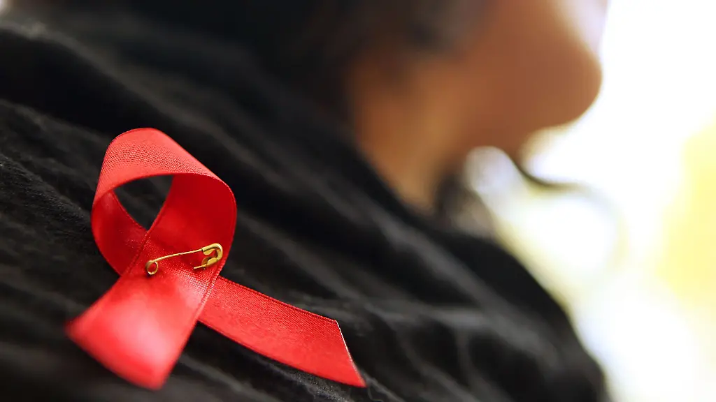 Eine-Frau-hat-sich-eine-rote-Schleife-angeheftet