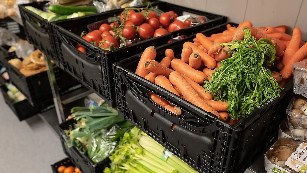 Obst-und-Gemuese-in-Kisten-liegen-in-einem-Regal