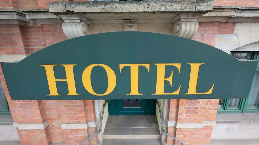 Ein-Schild-mit-der-Aufschrift-Hotel-haengt-an-einem-Hauseingang