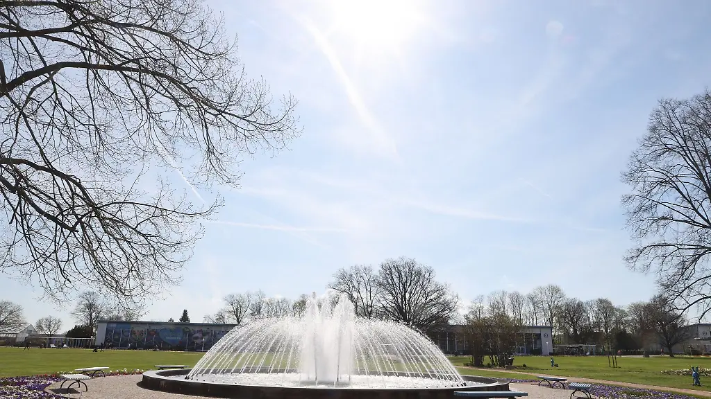Die-Sonne-strahlt-ueber-einem-Springbrunnen-in-Erfurt