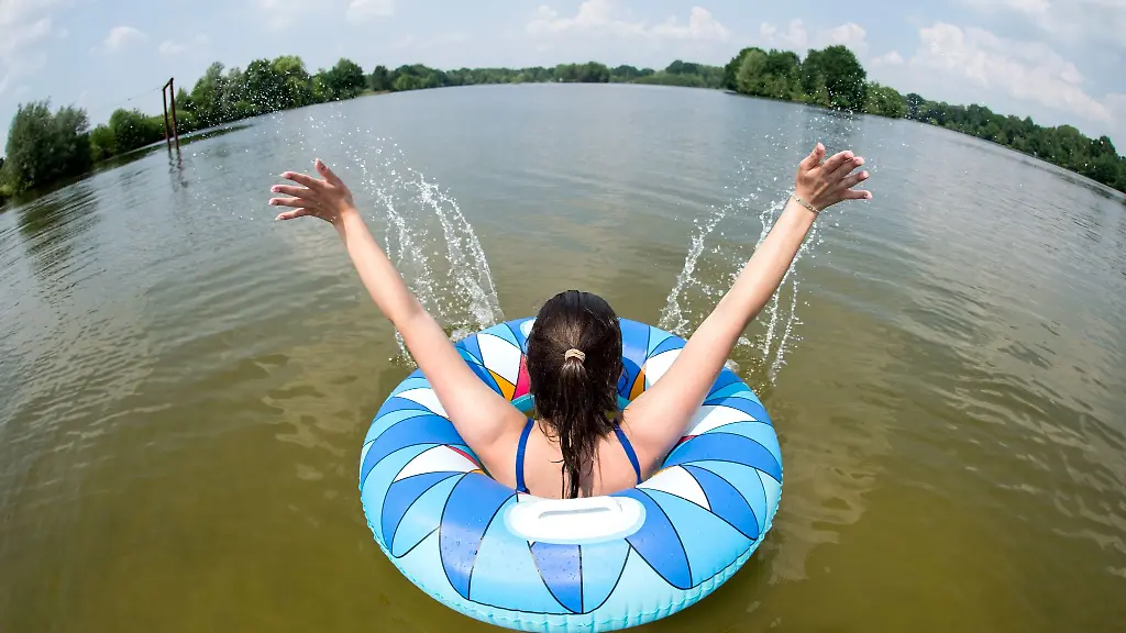 Eine-junge-Frau-badet-mit-einem-Schwimmreifen-im-Irenensee