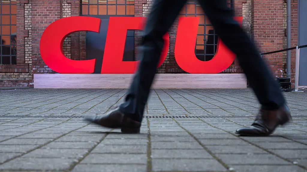 Ein-Passant-geht-an-einem-Logo-der-CDU-vorbei