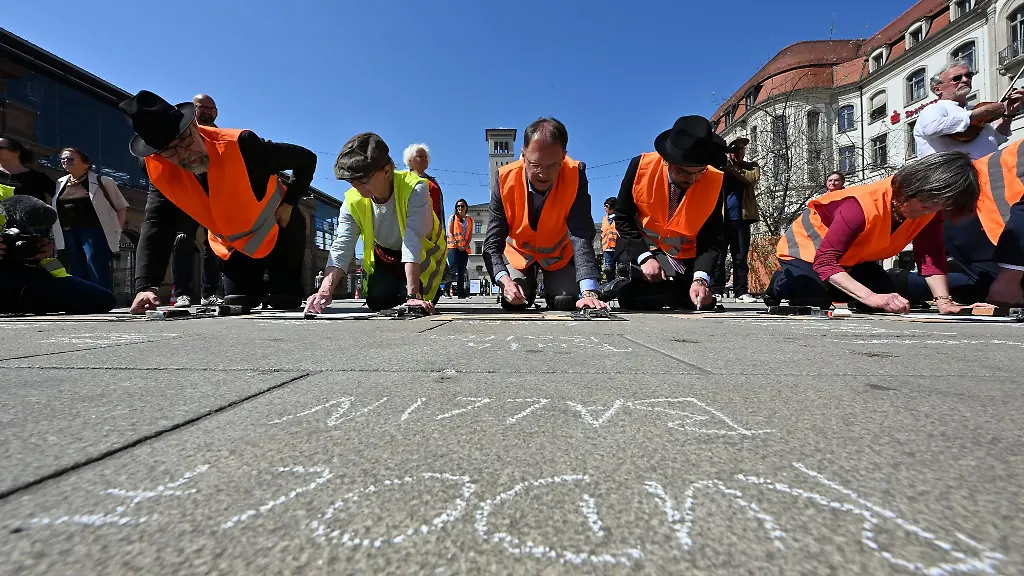 Frauen-und-Maenner-schreiben-Namen-auf-den-Willy-Brandt-Platz-vor-dem-Hauptbahnhof