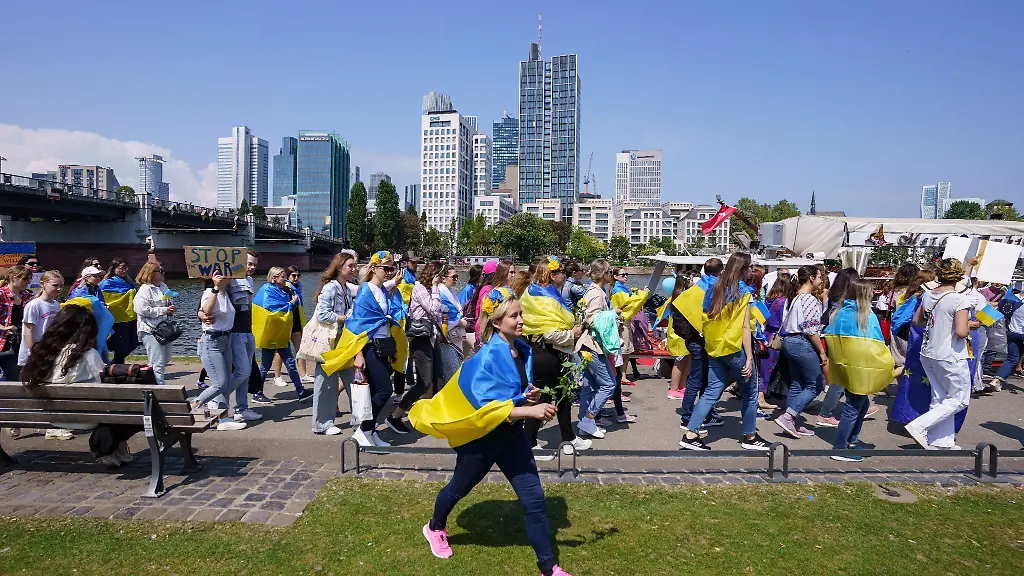 Mit-ukrainischen-Fahnen-sind-die-Teilnehmerinnen-bei-einer-Demonstration-unterwegs