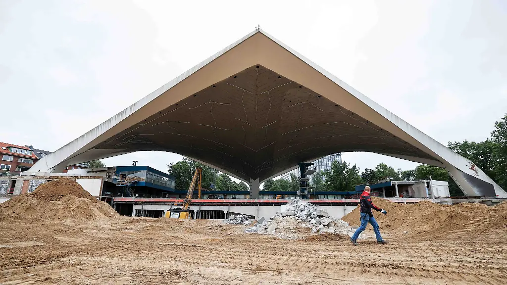 Ein-Arbeiter-geht-auf-der-Baustelle-an-dem-Dach-der-Alster-Schwimmhalle-vorbei