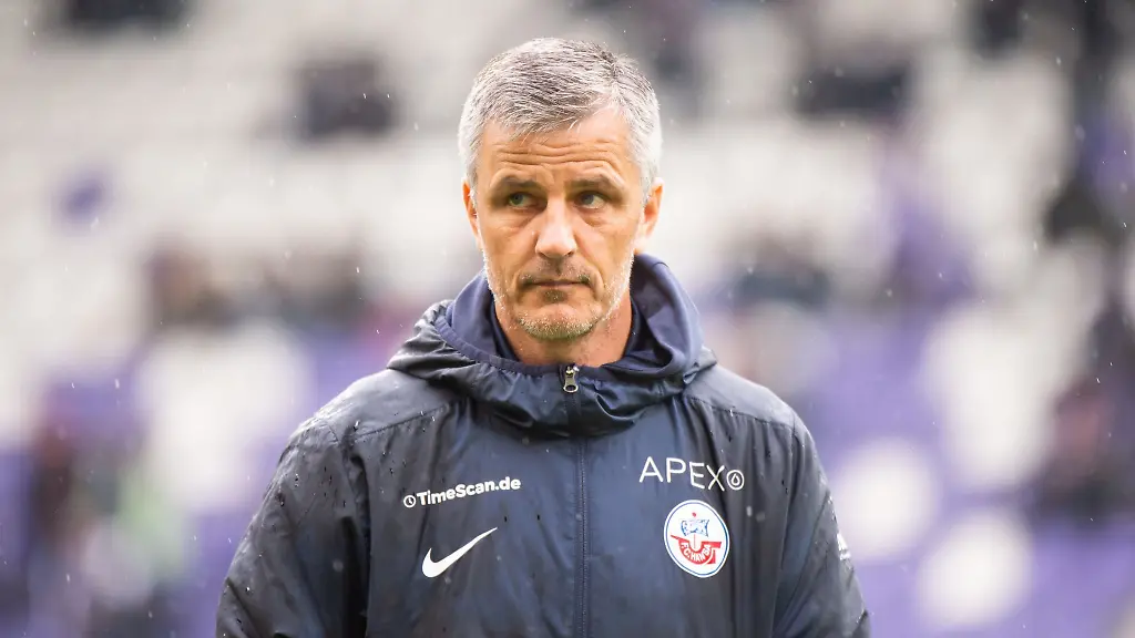 Hansa-Rostocks-Trainer-Jens-Haertel-steht-vor-einem-Spiel-auf-dem-Platz