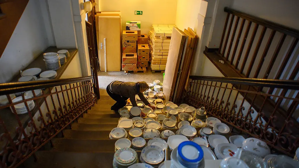 Eine-Helferin-sucht-in-einer-ehemaligen-Schule-in-Dessau-Rosslau-gespendetes-Geschirr-fuer-die-Gefluechteten-heraus