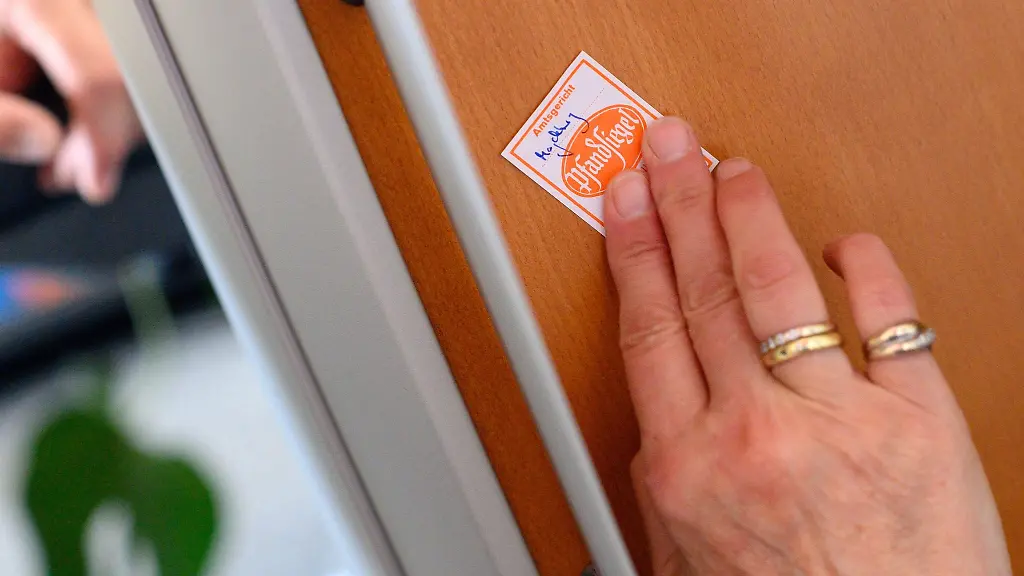 Eine-Gerichtsvollzieherin-klebt-ein-Pfandsiegel-auf-ein-technisches-Geraet