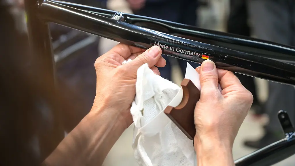 Der-Aufkleber-Made-in-Germany-wird-von-einer-Mitarbeiterin-an-einen-Fahrradrahmen-geklebt