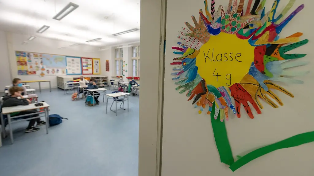 Schueler-und-Schuelerinnen-einer-vierten-Klasse-sitzen-mit-Abstand-zueinander-in-einem-Klassenraum