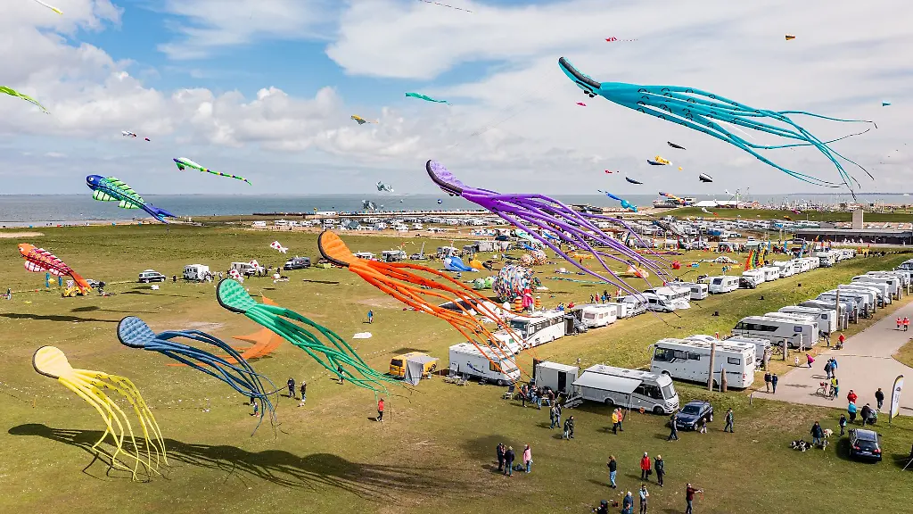 Zahlreiche-bunte-Drachen-in-unterschiedlichen-Groessen-sind-an-der-Nordseekueste-von-Dornumersiel-in-der-Luft