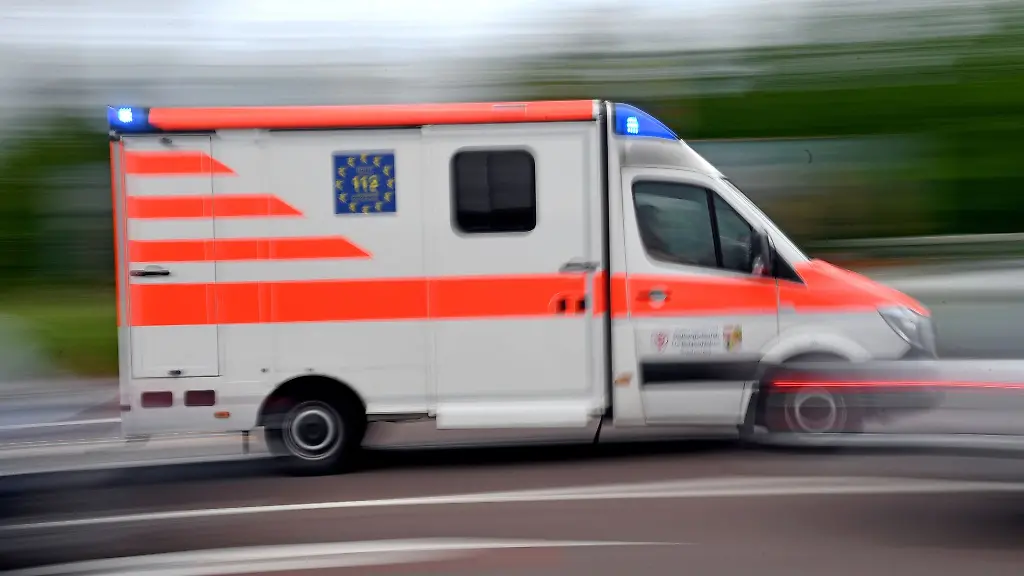 Ein-Krankenwagen-faehrt-mit-Blaulicht-auf-einer-Strasse