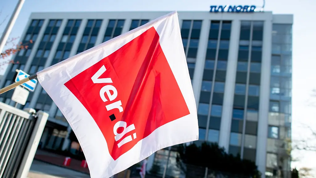 Ein-Gewerkschaftsmitglied-schwenkt-eine-Fahne-mit-dem-Logo-von-Verdi