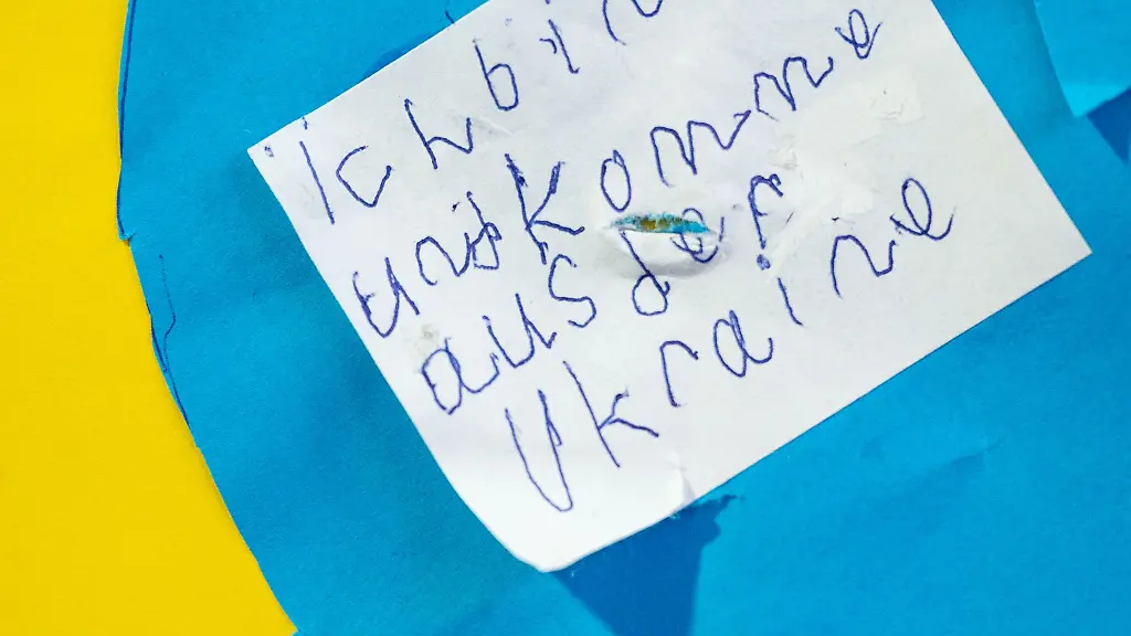 Ein-Zettel-mit-der-Aufschrift-Ich-bin-und-komme-aus-der-Ukraine-haengt-an-der-Tuer-einer-Schule