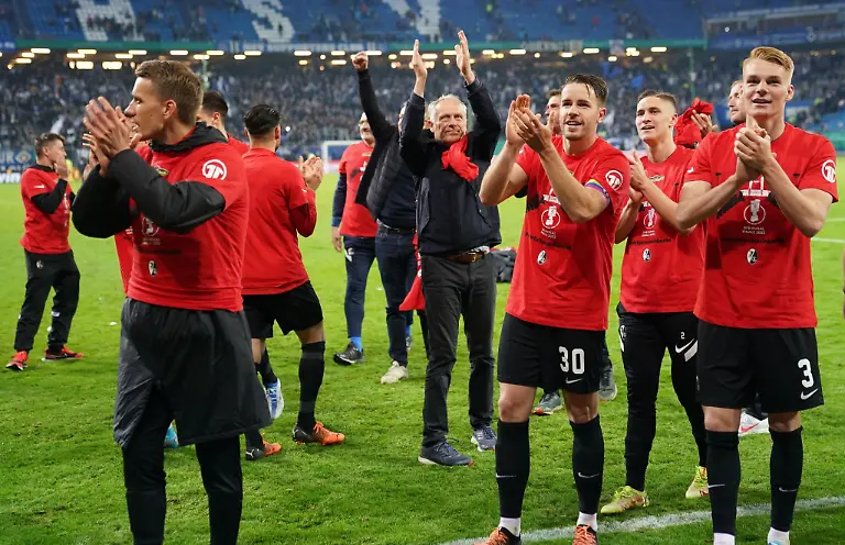 Die-Spieler-des-SC-Freiburg-freuen-sich-mit-Trainer-Christian-Streich-M-ueber-den-Einzug-ins-Finale-des-DFB-Pokals