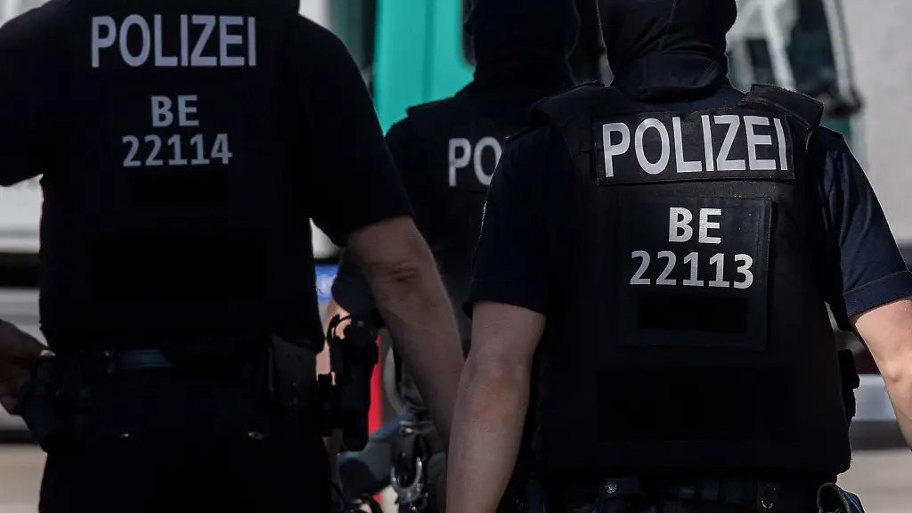 Berliner-Polizisten-gehen-ueber-eine-Strasse