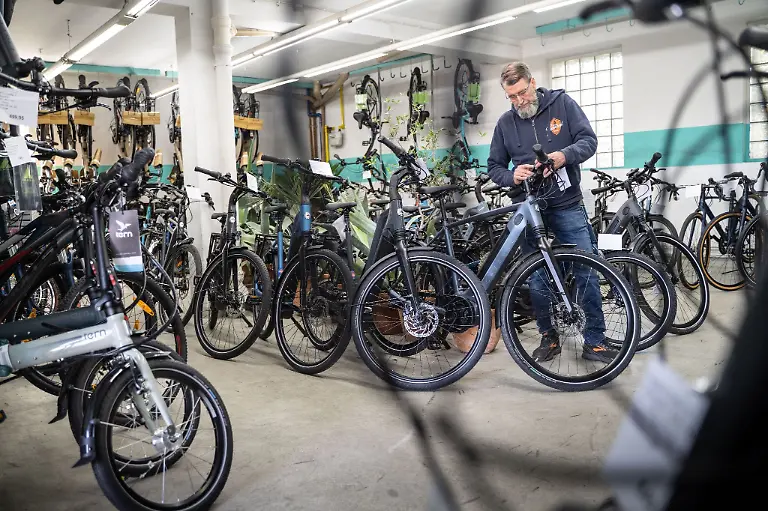 Zweiradmechanikermeister-Thomas-Schuett-steht-zwischen-neuen-Fahrraedern