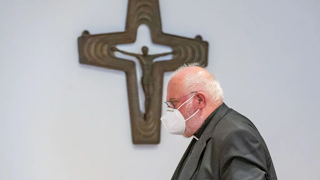 Kardinal-Reinhard-Marx-Erzbischof-von-Muenchen-geht-nach-einer-Pressekonferenz-neben-einem-Kreuz