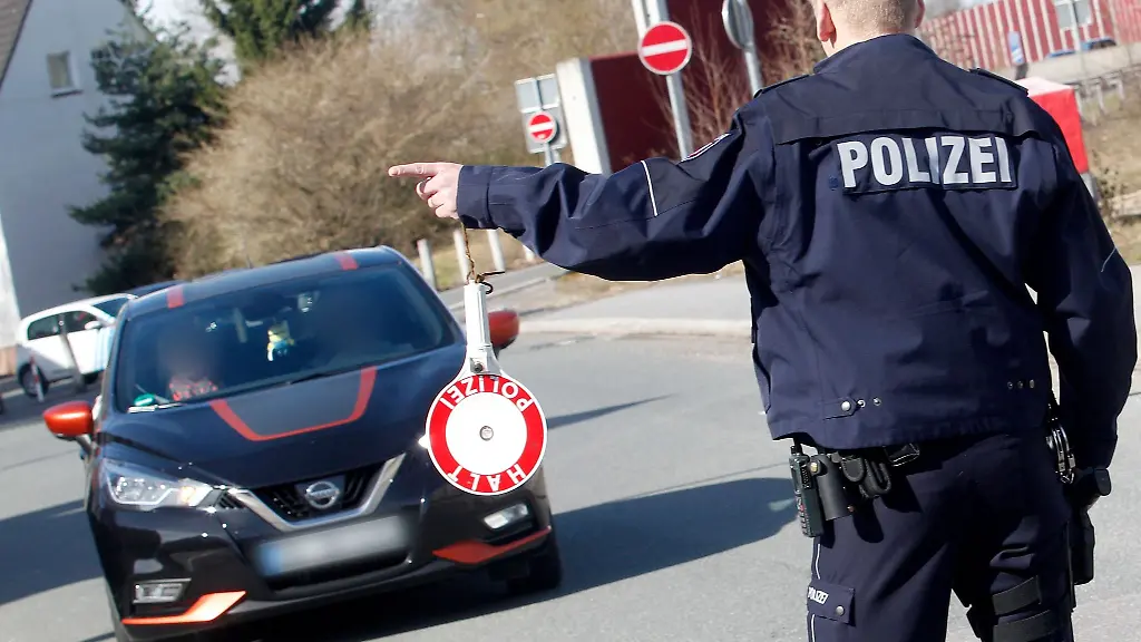 Ein-Polizist-winkt-ein-getuntes-Auto-bei-einem-Tuning-Treffen-zur-Kontrolle-heraus