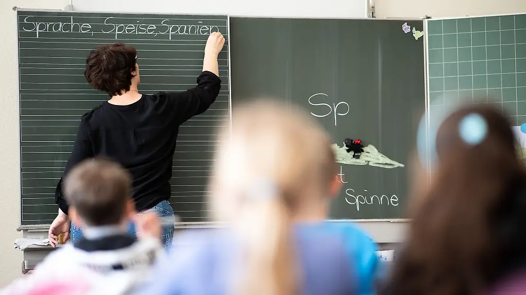 Eine-Lehrerin-schreibt-in-einer-Schule-an-die-Tafel