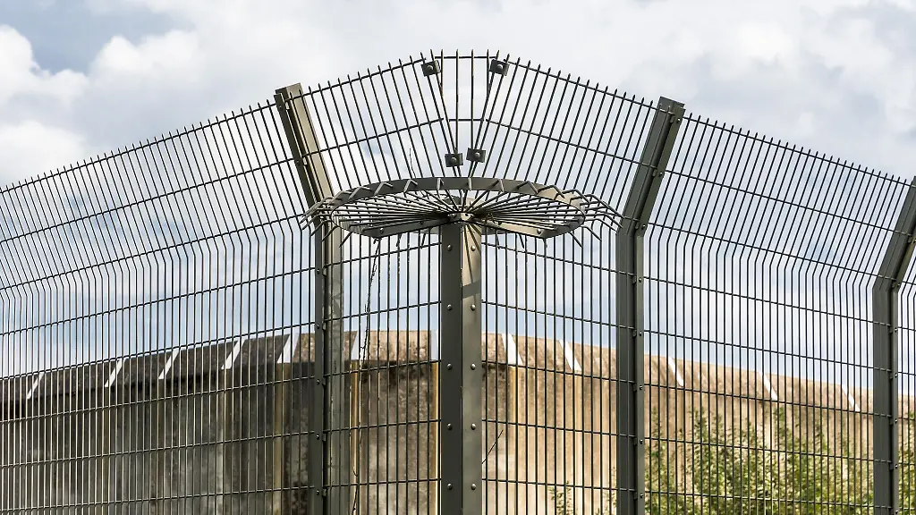 Eine-Mauer-und-ein-Drahtzaun-eines-Gefaengnisses