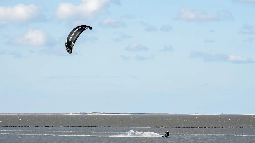 Ein-Kitesurfer-ist-bei-sonnigem-Wetter-unterwegs