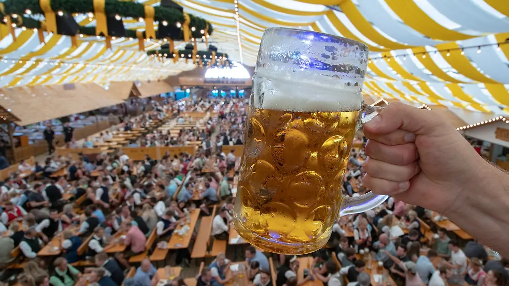 Eine-Mass-Bier-wird-in-einem-Festzelt-auf-dem-Gelaende-des-Gaeubodenvolksfestes-hochgehalten