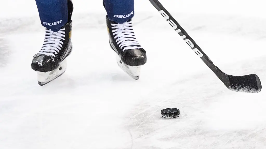 Ein-Eishockeyspieler-spielt-den-Puck